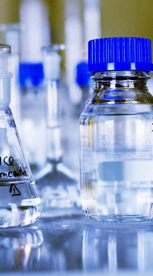 Chemicals in glass containers on table at laboratory Chemicals in glass containers on table at laboratory