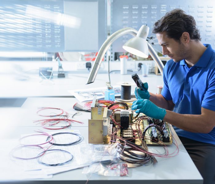 Worker assembling electronics in electronics factory Worker assembling electronics in electronics factory